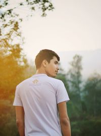 Full length of young man looking away against sky