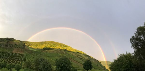 Rainbow over landscape against sky