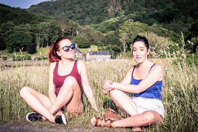 Portrait of smiling young couple sitting on land