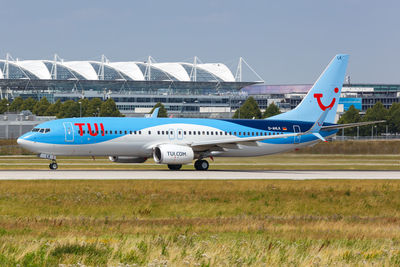 Side view of airplane on runway against sky