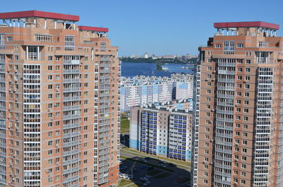 Buildings by sea against clear sky