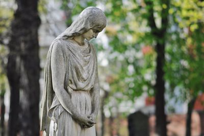 Sad female statue at cemetery