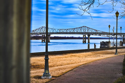 Bridge over river against cloudy sky