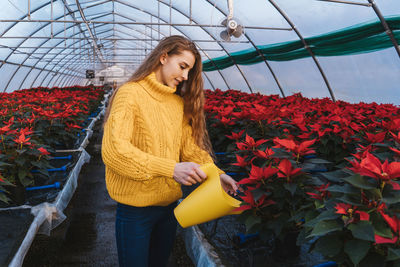 Young woman standing by flowering plants