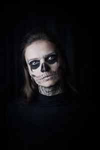 Portrait of woman with make-up during halloween against black background