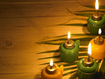 Close-up of illuminated oil lamps on table