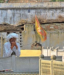 Man holding flag in front of building