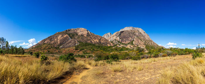 Scenic view of rocky mountains against blue sky