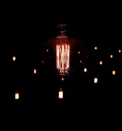 Close-up of illuminated lamp against black background