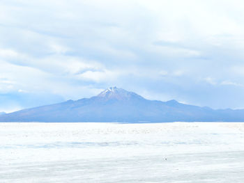 Scenic view of sea and mountains against sky