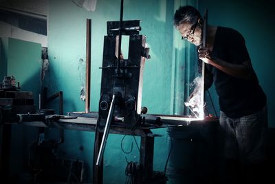 Rear view of man working in workshop