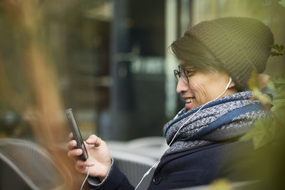 Man using cell phone in outdoor cafe