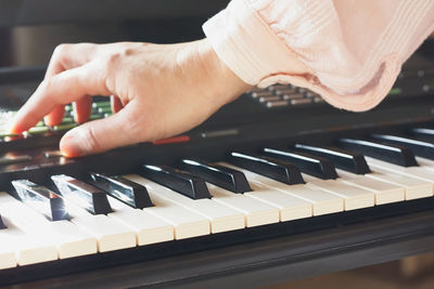 Female musician playing the digital piano or electronic keyboard at home. music education online. 