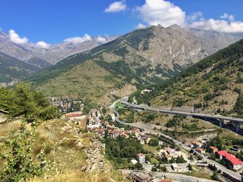 Scenic view of road by buildings against sky