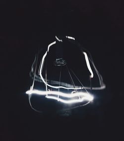 Illuminated ferris wheel against black background