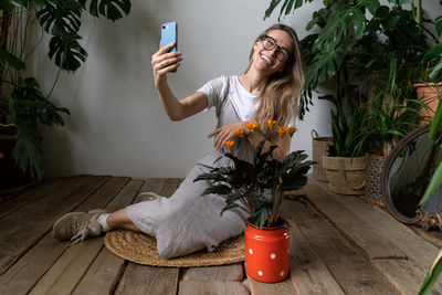 Young woman using mobile phone while sitting on floor