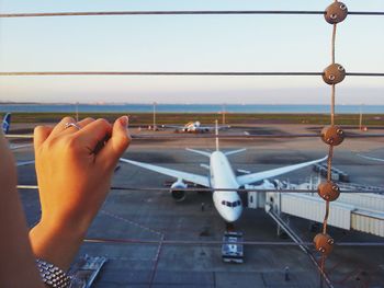 Cropped woman hand on security fence in haneda airport