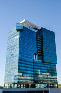 Low angle view of modern building against blue sky