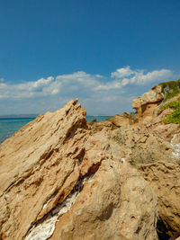 Rock formation on beach against sky
