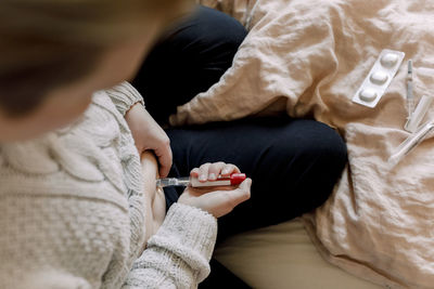 Directly above shot of woman doing in vitro fertilization test at home