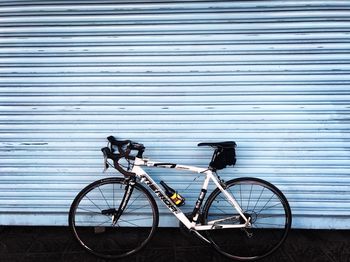 Bicycle parked against closed shutter