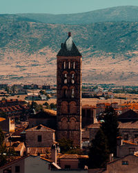 High angle view of old tower amidst buildings in city