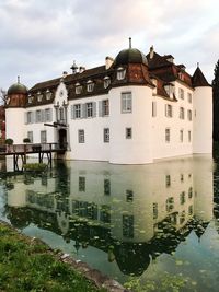 Reflection of houses in water against sky