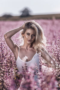 Portrait of beautiful young woman against purple flowering plants