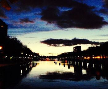 Reflection of illuminated buildings in water at dusk