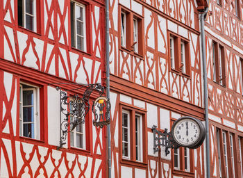 Low angle view of clock hanging on building