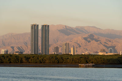 Scenic view of sea by mountains against clear sky