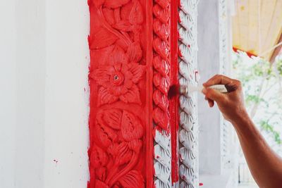 Cropped hand of person painting wall