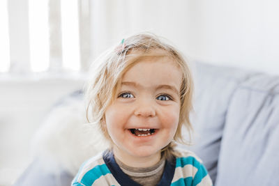 Portrait of cute happy girl with gray eyes at home