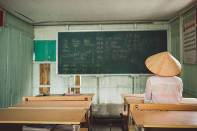 Rear view of person sitting in classroom