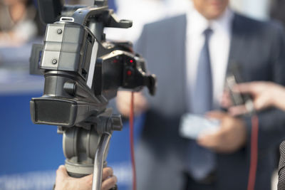 Cropped image of journalist filming businessman