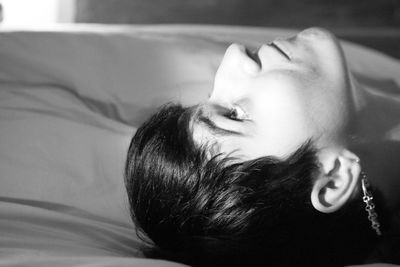 Close-up of woman relaxing on bed at home