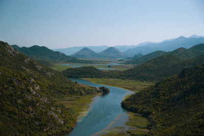 Scenic view of river amidst mountains against clear sky