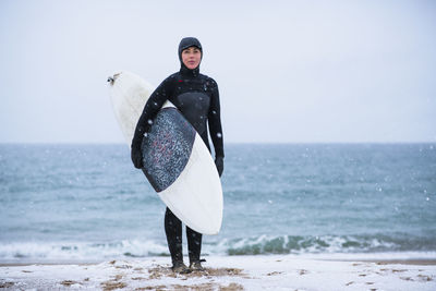 Young woman going winter surfing in snow