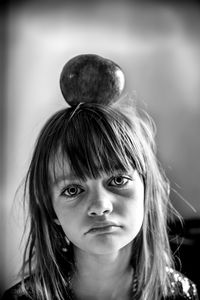 Portrait of a sad girl with apple on her head.