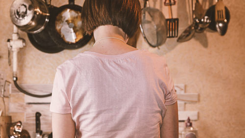 Rear view of woman working in kitchen at home