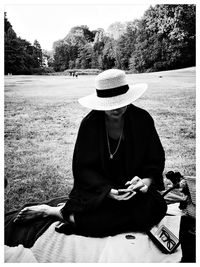 Rear view of man sitting on field