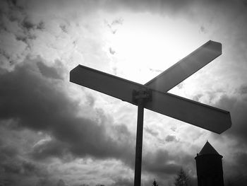 Low angle view of road sign against cloudy sky