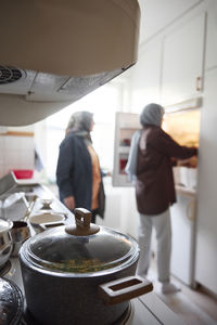 Women in headscarves cooking together for eid al-fitr at home