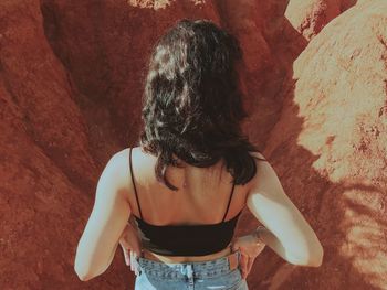 Rear view of woman standing against wall