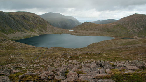 Scenic view of lake and mountains against cloudy sky