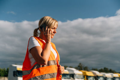 Side view of mechanic talking on smart phone