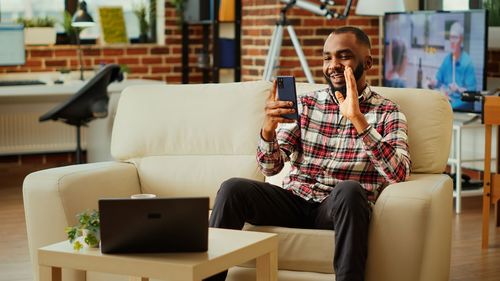 Young woman using laptop while sitting on sofa at home