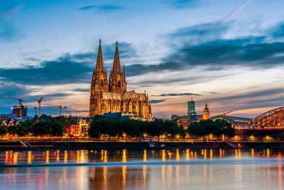 Panoramic view of cologne cathedral with hohenzollern bridge at nightfall, germany.