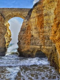 Scenic view of rock formation in sea against sky