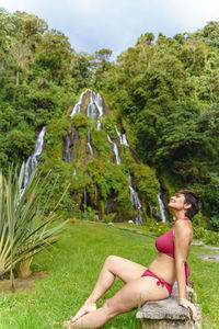 Portrait of young woman sitting on mountain